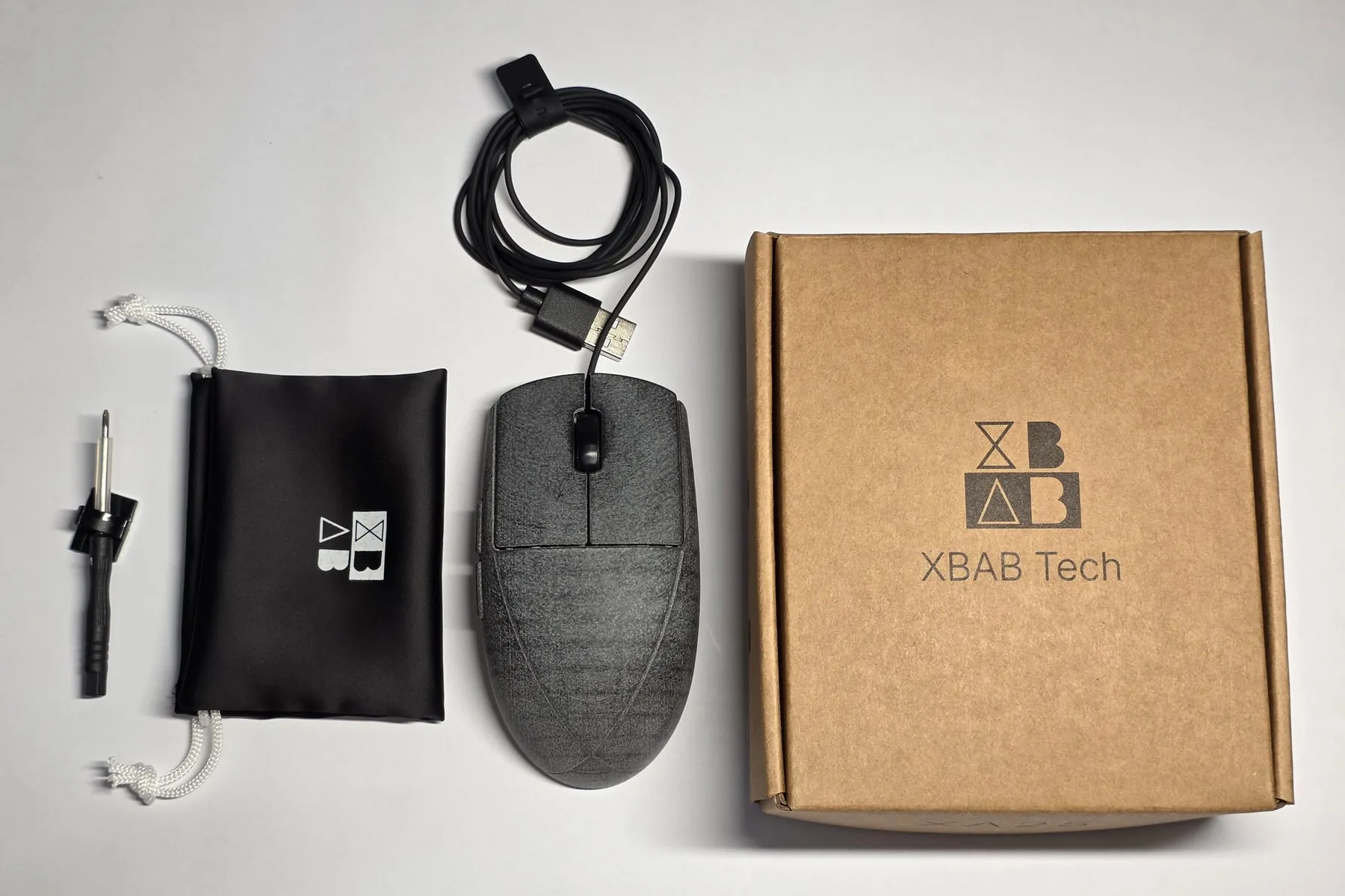 The XA25 with its cable and the adhesive clip, the cloth carrying bag, the screwdriver, and the kraft cardboard box